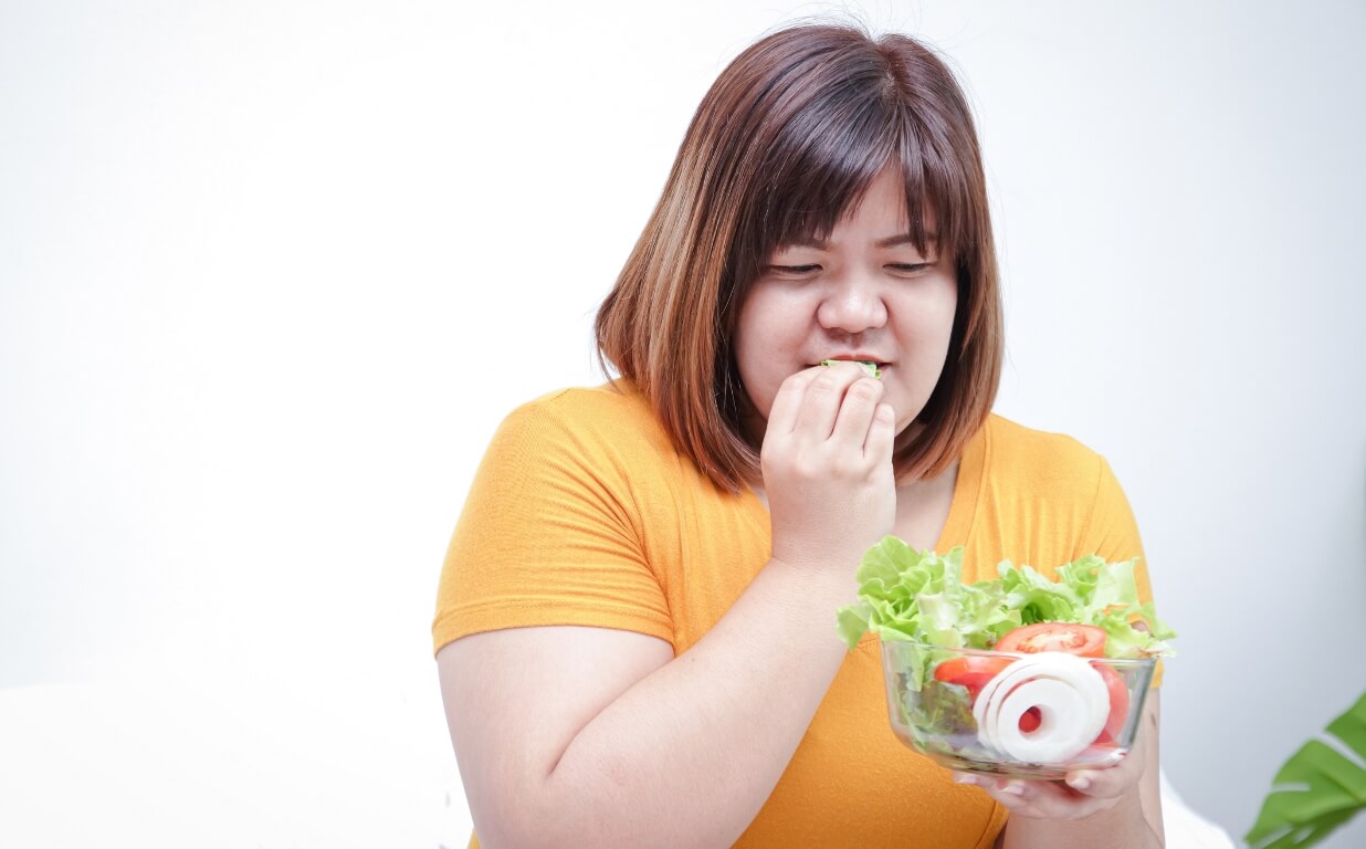 Fat Asian women eat fresh vegetables to lose weight