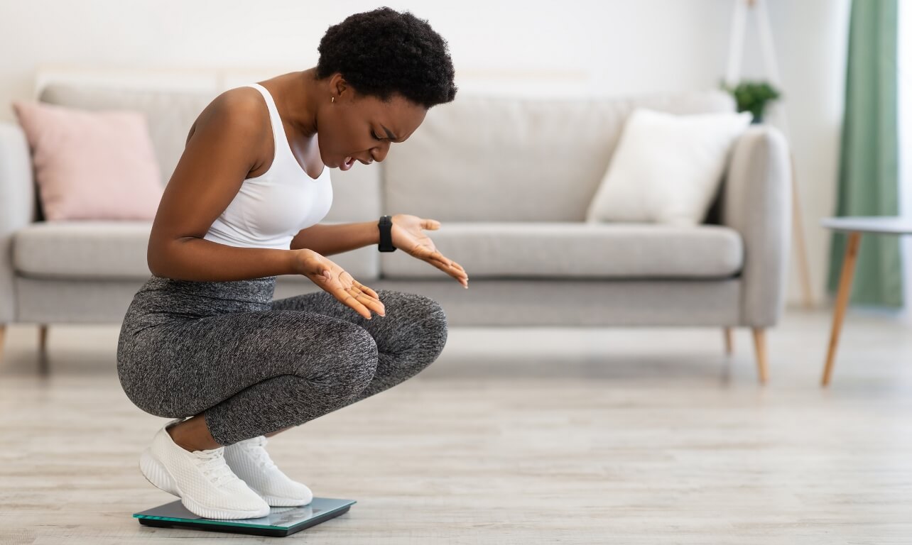 Frustrated Black Lady Looking At Scales In Shock Discontented With Weight