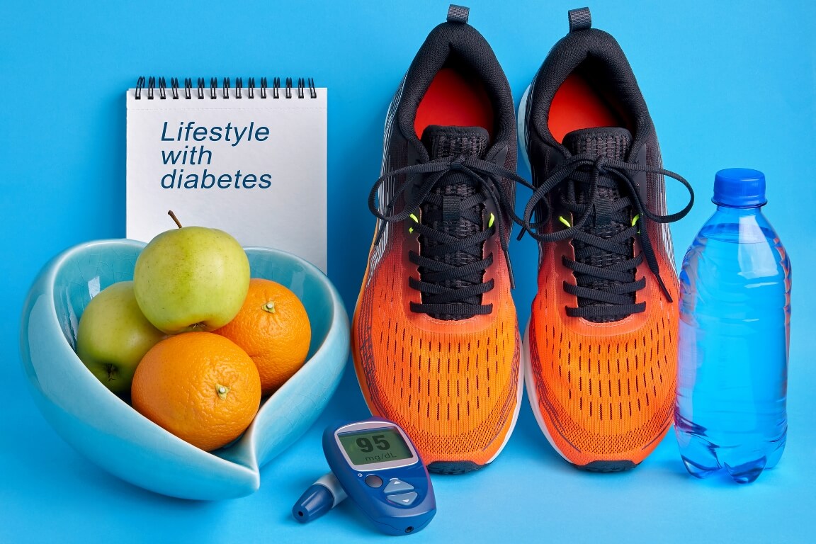 Orange sneakers, a notebook diary, a glucometer, a bottle of drinking water and fruits on a blue background, healthy lifestyle to maintain normal blood glucose levels 