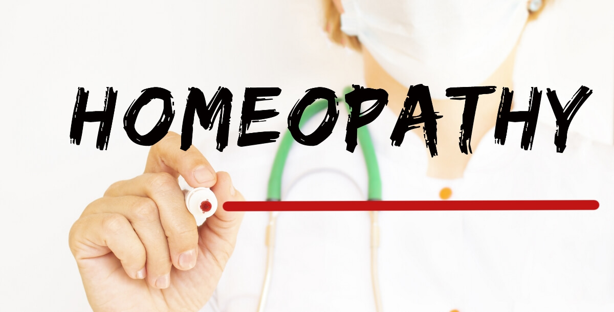 The doctor writes the text HOMEOPATHY with a marker. Medical 